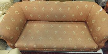 A late Victorian Chesterfield sofa on bun front feet, upholstered in terracotta foliate patterned
