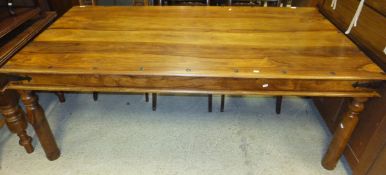 An Oriental hardwood rectangular dining table with iron nails and bandings on turned legs