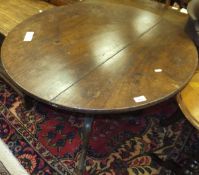 An 18th Century mahogany circular tea table with snap top on turned and ringed central pedestal to