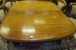 A Victorian mahogany rounded rectangular extending dining table on heavy fluted and carved turned