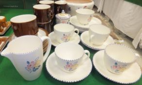 A collection of Poole pottery table wares decorated with floral sprays on a cream ground and with