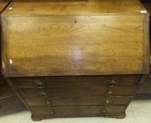 A 19th Century oak bureau, the plain top above a sloping fall enclosing fitted interior,