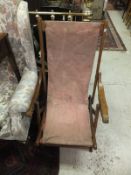 A vintage folding wooden deckchair with red cover,