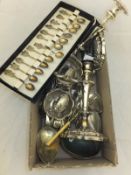 A box of assorted plated cutlery together with a pair of plated candlesticks,