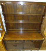 A mid 20th Century oak dresser, the plate rack above two heavily carved drawers over two pairs of