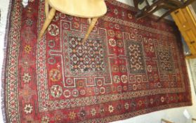 A Caucasian rug, the three central rectangular medallions in shades of red, apricot, grey,