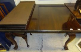 An Edwardian mahogany rounded rectangular dining table, the top with two extra leaves,