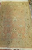 A Caucasian rug, the salmon centre field with stylised floral decoration in cream,