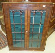 A 19th Century mahogany corner cupboard with astragal glazed doors and ivory escutcheons opening to