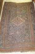 A Quashqai rug, the three central diamond medallions in blue, terracotta and cream on a dark blue,