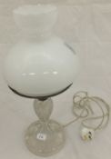 A late 19th / early 20th Century cut glass table lamp with milk glass shade