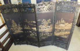 A Chinese ebonised and carved framed four fold screen with needlework fabric panels depicting