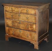 An 18th Century walnut and oak chest, the top with moulded edge above two short and three long