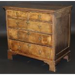 An 18th Century walnut and oak chest, the top with moulded edge above two short and three long