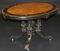 A Victorian ebonised and amboyna and inlaid breakfast table in the manner of Holland & Sons,