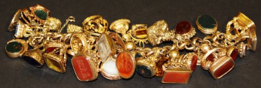 A gold charm bracelet set with 36 various seals (to include Georgian and later), lockets, etc approx