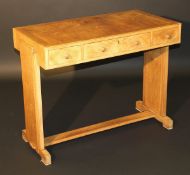 A mid 20th Century Heals walnut writing table, the cross-banded top with moulded edge above three