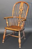 A Victorian Windsor style ash stick back elbow chair, the central carved splat above a plain seat on