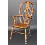 A Victorian Windsor style ash stick back elbow chair, the central carved splat above a plain seat on