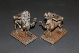 A pair of Chinese bronze stands as stylised lion and stylised cow,