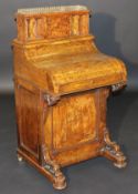 A Victorian walnut Davenport with pop-up top and piano front with rising surface over a maple