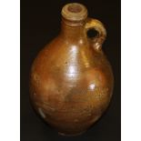 A 17th Century salt-glazed flagon with loop handle and winged decoration to neck,