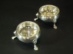 A pair of George V cauldron type salts with gadrooned edge and raised on three hoof feet,