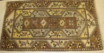 A Caucasian rug, the centre field with medallion and motif decoration in pale yellow, cream, blue,