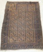 A Beluch prayer rug, the centre field with repeating medallions in madder,