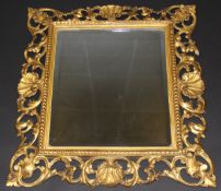 A late 19th / early 20th Century Florentine carved giltwood and gesso framed wall mirror with