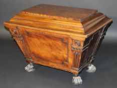An early 19th Century mahogany wine cooler of sarcophagus form, on heavy lion's paw feet, 82 cm wide
