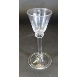 An 18th Century wine glass with funnel shaped bowl and knop to the top of the straight stem with