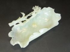 A Chinese jade washing bowl in the form of a leaf with flower decoration to edge, approx 10 cm