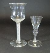 A mid 18th Century goblet with a tall waisted cup shaped bowl and multiple spiral air twist stem