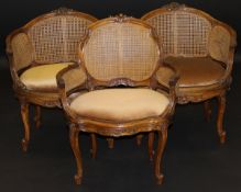 A pair of circa 1900 carved walnut framed bérgère salon chairs in the Louis XV taste, and another