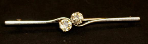 A white gold and two diamond set bar brooch,