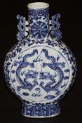 A Chinese porcelain moon flask decorated in underglaze blue to both sides with dragons, and with