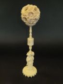 An early 20th Century ivory puzzle ball on stand, the stand with figure to base, approx 30.