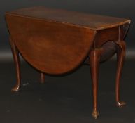 A late George III mahogany oval drop leaf dining table on cabriole legs to shaped padded feet,