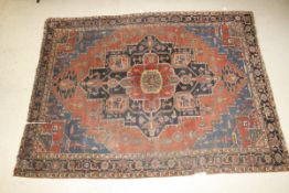 A Caucasian carpet, the central medallion in blue, salmon, red, green and cream on a red medallion