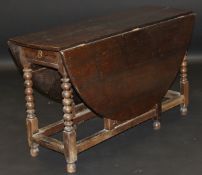 An 18th Century style oak oval drop leaf gate leg dining table,