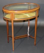 An Edwardian oval mahogany bijouterie table with marquetry inlay on square tapered legs to spade