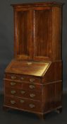 An 18th Century walnut bureau bookcase, the top with moulded cornice over two cupboard doors