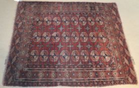 A Tekke Bokhara rug, the centre field with repeating elephant foot medallions in pale terracotta,
