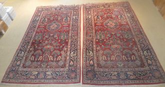 A pair of Kashan rugs, the centre fields with vase and flower, tree and medallion decoration in