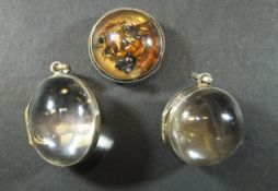 Two rock crystal and gilt metal locket pedants, one of spherical form, the other oval, together with