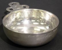 An oversized late Victorian beaten silver tastevin with openwork handle in the Celtic taste