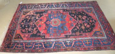 A Caucasian rug, the central medallion in red, blue,