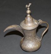 A small Turkish bronze coffee pot of typical form with bird finial and scrolling spout opposite an