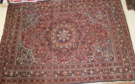 A Persian carpet, the central floral medallion in shades of blue, peach, cream and red,